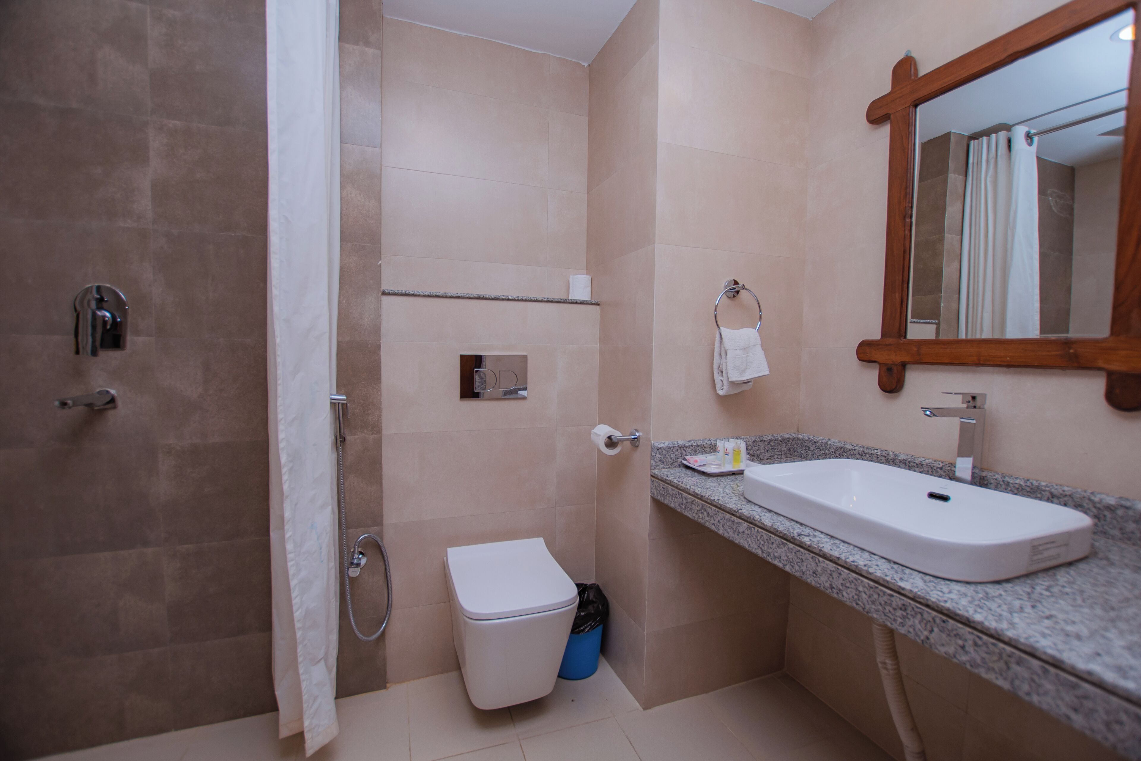 Ein Badezimmer mit Dusche, Toilette, Waschbecken und Spiegel.