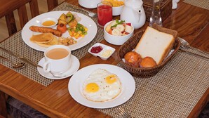 A dining table set with breakfast items including eggs, toast, and fruit, with chairs around it. - Hotel Hidden Kingdom (Pokhara)