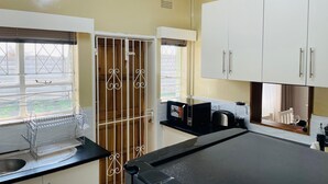 A kitchen with a sink, a coffee machine, and cabinets. - Immaculate Home in Avondale West - 2166 (Harare)