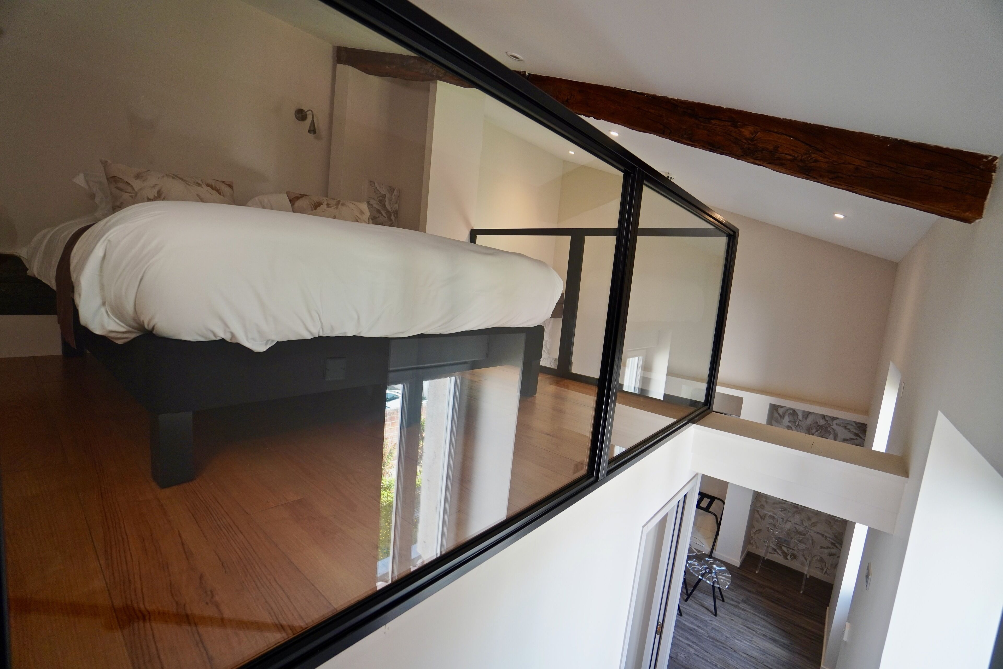 Une chambre moderne avec un grand lit, un plafond en verre et une vue sur l’extérieur.