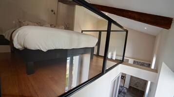 Un dormitorio moderno con una cama grande, techo de cristal y vistas al exterior.