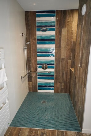 Een douche met een houten wand en een betegeling in blauw en wit gestreept.