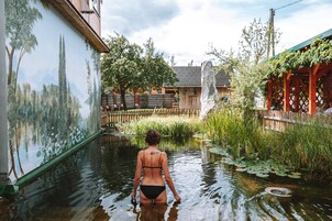 Una piscina al aire libre, sombrillas, sillones reclinables de piscina