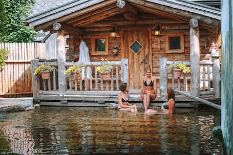 Una piscina al aire libre, sombrillas, sillones reclinables de piscina