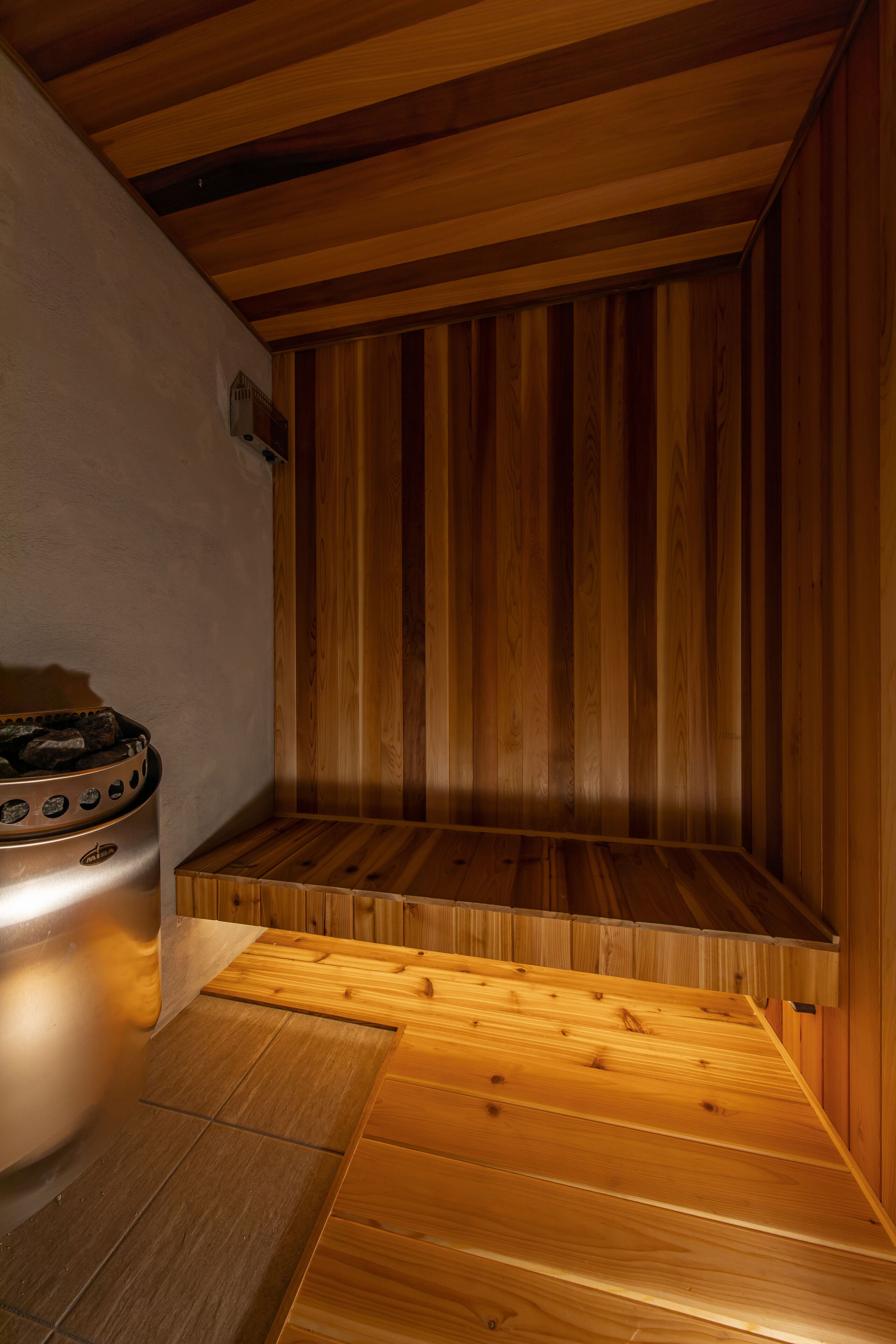 A sauna room with wooden walls and a bench.