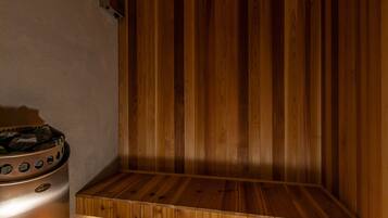 A sauna room with wooden walls and a bench.