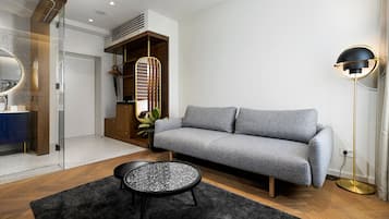 A modern living room with a grey sofa, a round coffee table, and a floor lamp.