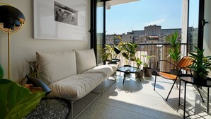A balcony with a sofa, chairs, and potted plants. - Dominic Smart & Luxury Suites - Edition (Belgrade)