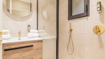 Une salle de bain moderne avec une douche à parois de verre, un meuble-lavabo en bois et un grand miroir.
