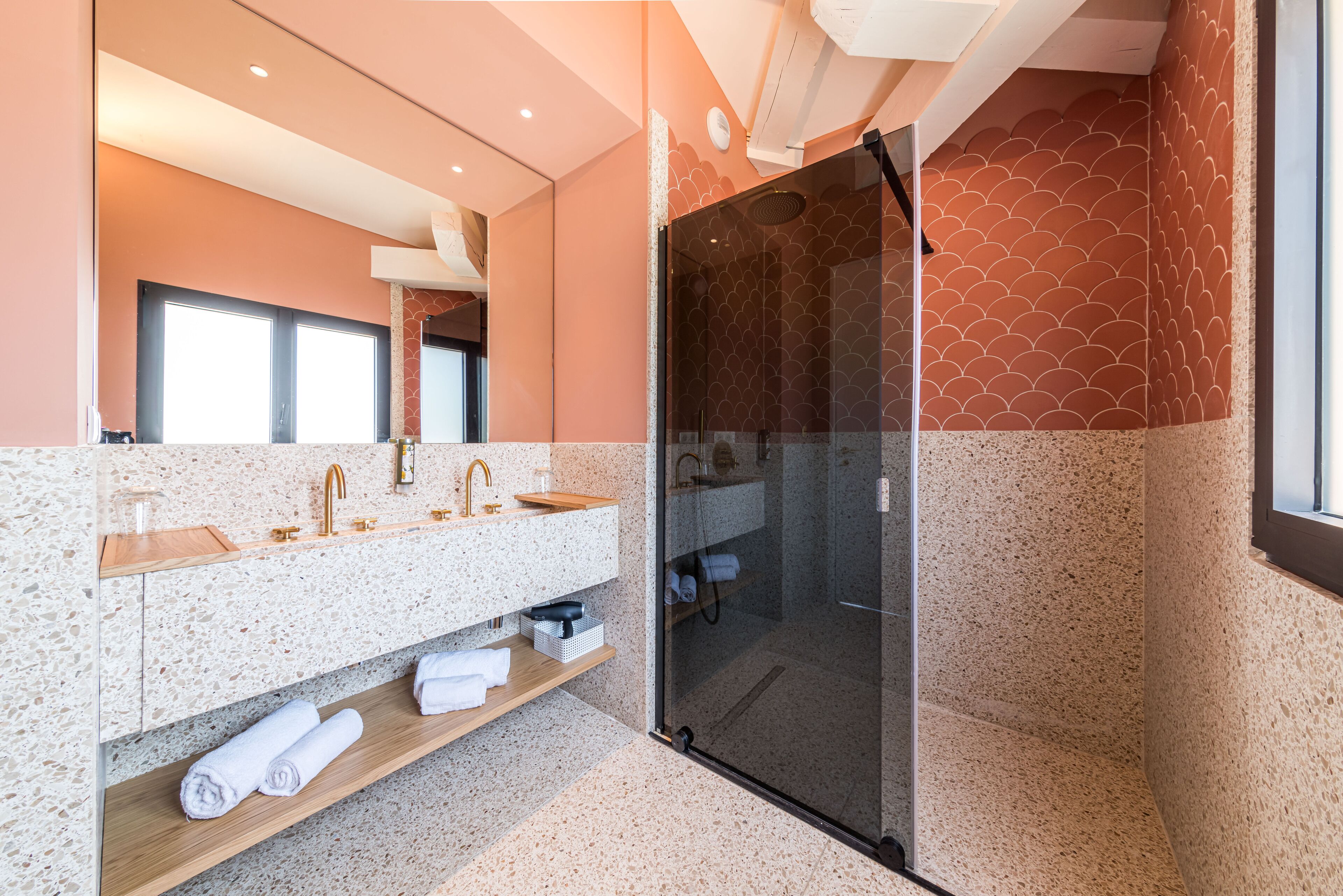 A modern bathroom with a glass-enclosed shower, a double sink vanity, and a large mirror.