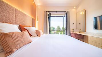 A modern hotel room with a large bed, a balcony with a view, and a well-lit bathroom.
