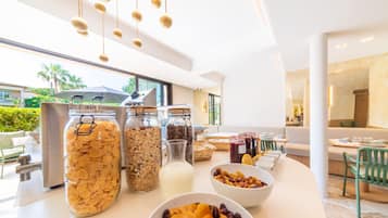 Ein Frühstücksbuffet mit Müsli, Milch und Obst.