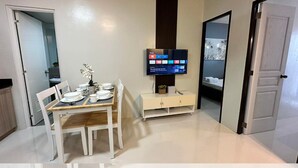 Una sala de estar moderna con comedor, un televisor de pantalla plana en la pared y un diseño minimalista.