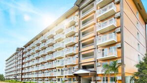Un hotel de varios pisos con balcones, techo plano y cielo despejado.