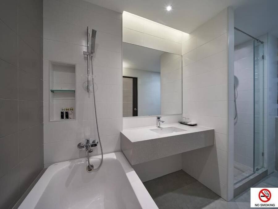 A modern bathroom with a bathtub, a glass-enclosed shower, and a vanity with a mirror.