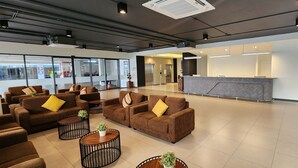A spacious lobby with sofas and round tables, a reception desk, and a large window with a view. - Prom Thailand Cultural Centre Hotel Annex2 (Bangkok)