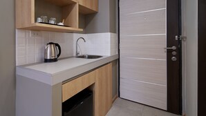 A compact kitchen with wooden cabinets, a stainless steel sink, and a dishwasher. - Prom Thailand Cultural Centre Hotel Annex2 (Bangkok)