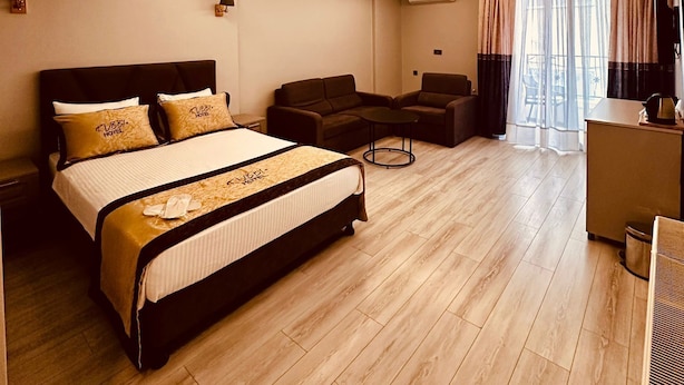A modern hotel room with a large bed, a desk, a sofa, and a dining table. - Rubby Kadıköy (Istanbul)