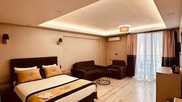 Deluxe Room with Balcony | Caja fuerte, espacio para trabajar con un portátil, cortinas opacas