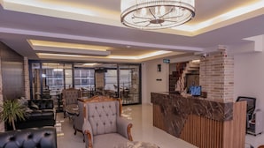 A modern lobby with a reception desk, leather seating, and a chandelier. - Rubby Kadıköy (Istanbul)