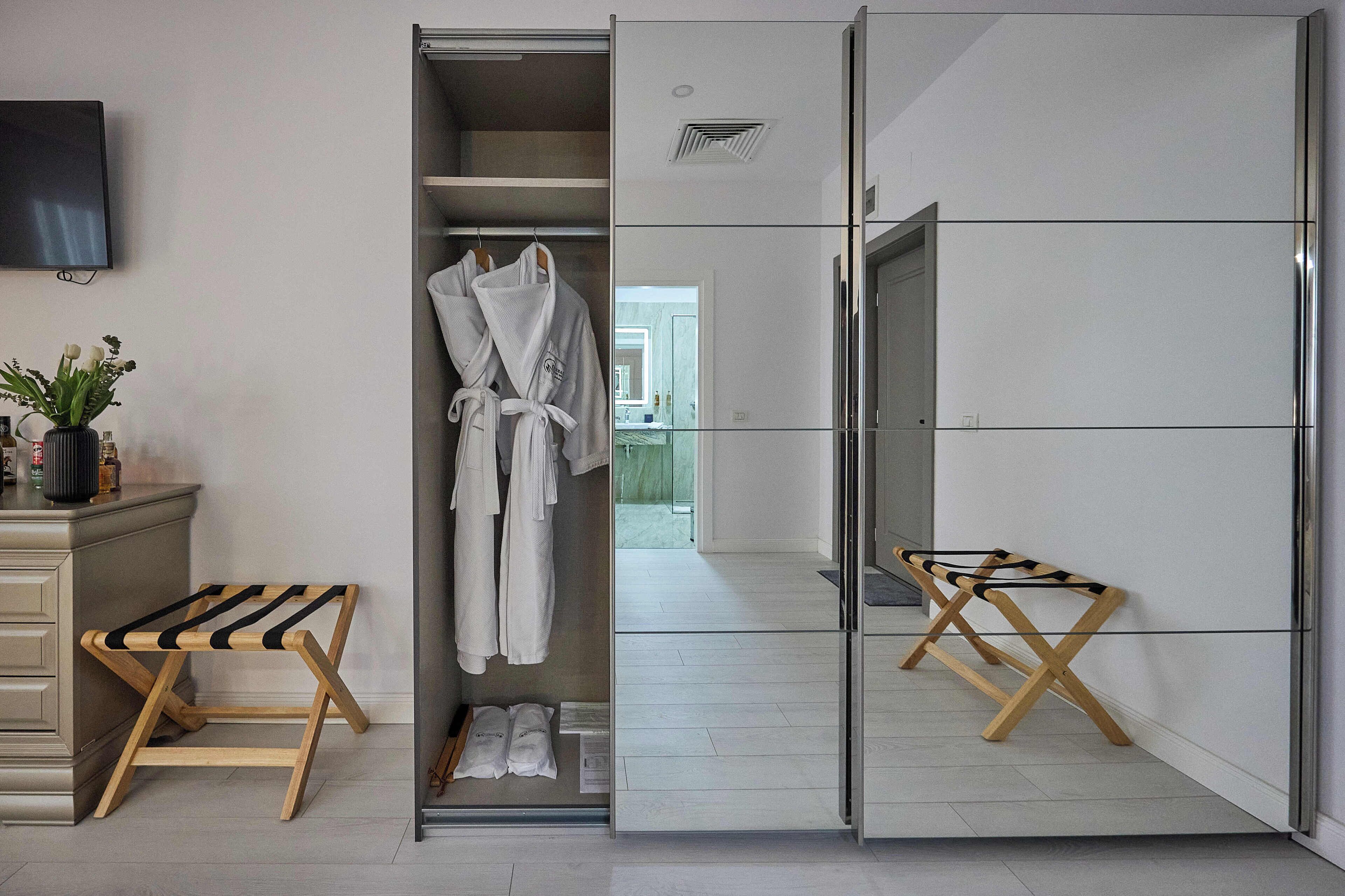 Un baño moderno con cabina de ducha, tocador con cierre de vidrio y banco de madera.