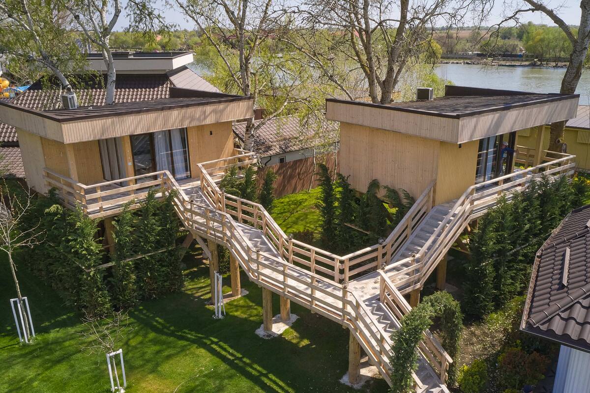 A modern house with two separate units, each with a balcony and a staircase leading to a deck.