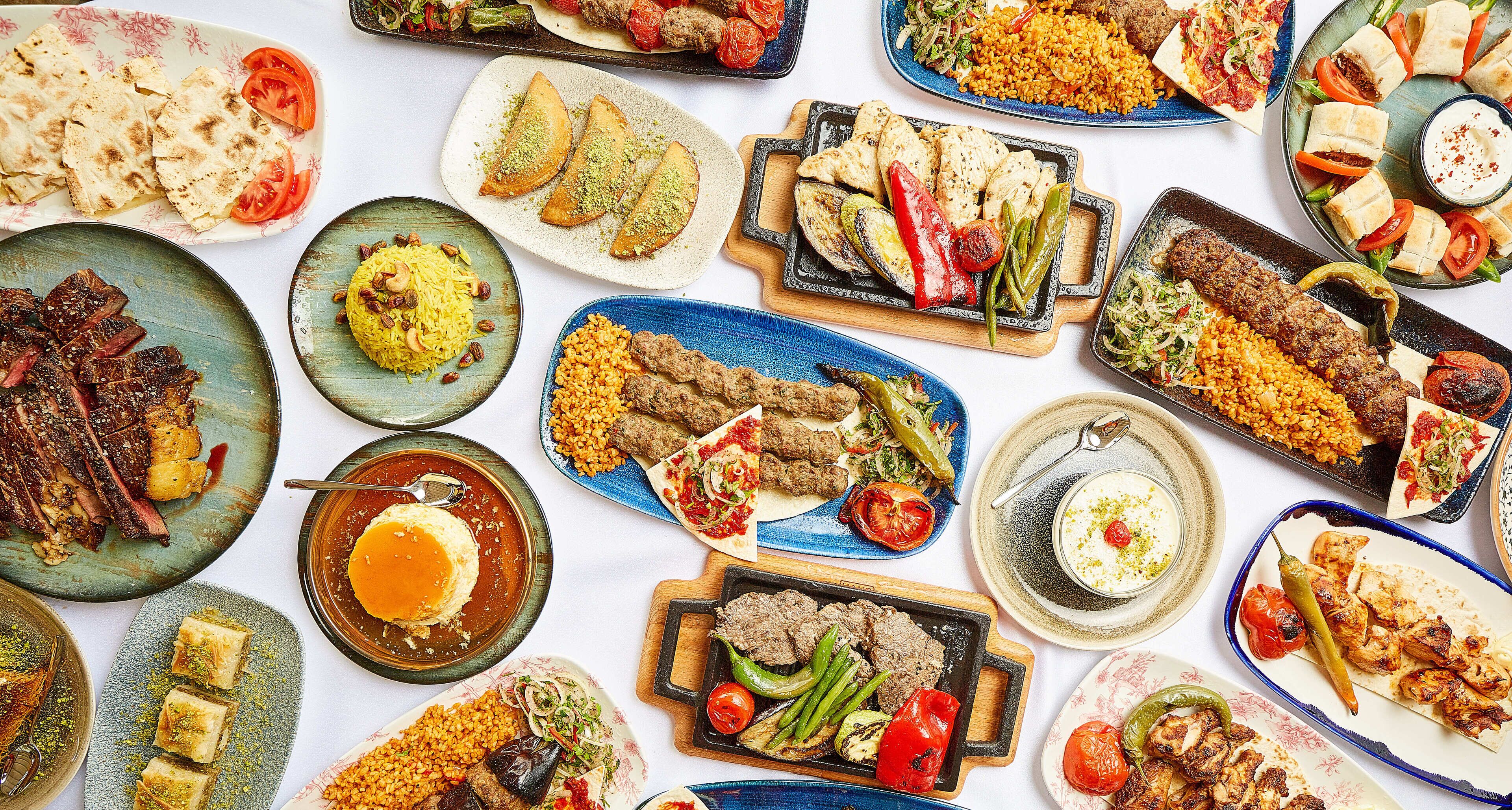 Una variedad de platos sobre una mesa, incluyendo carnes, verduras y arroz.
