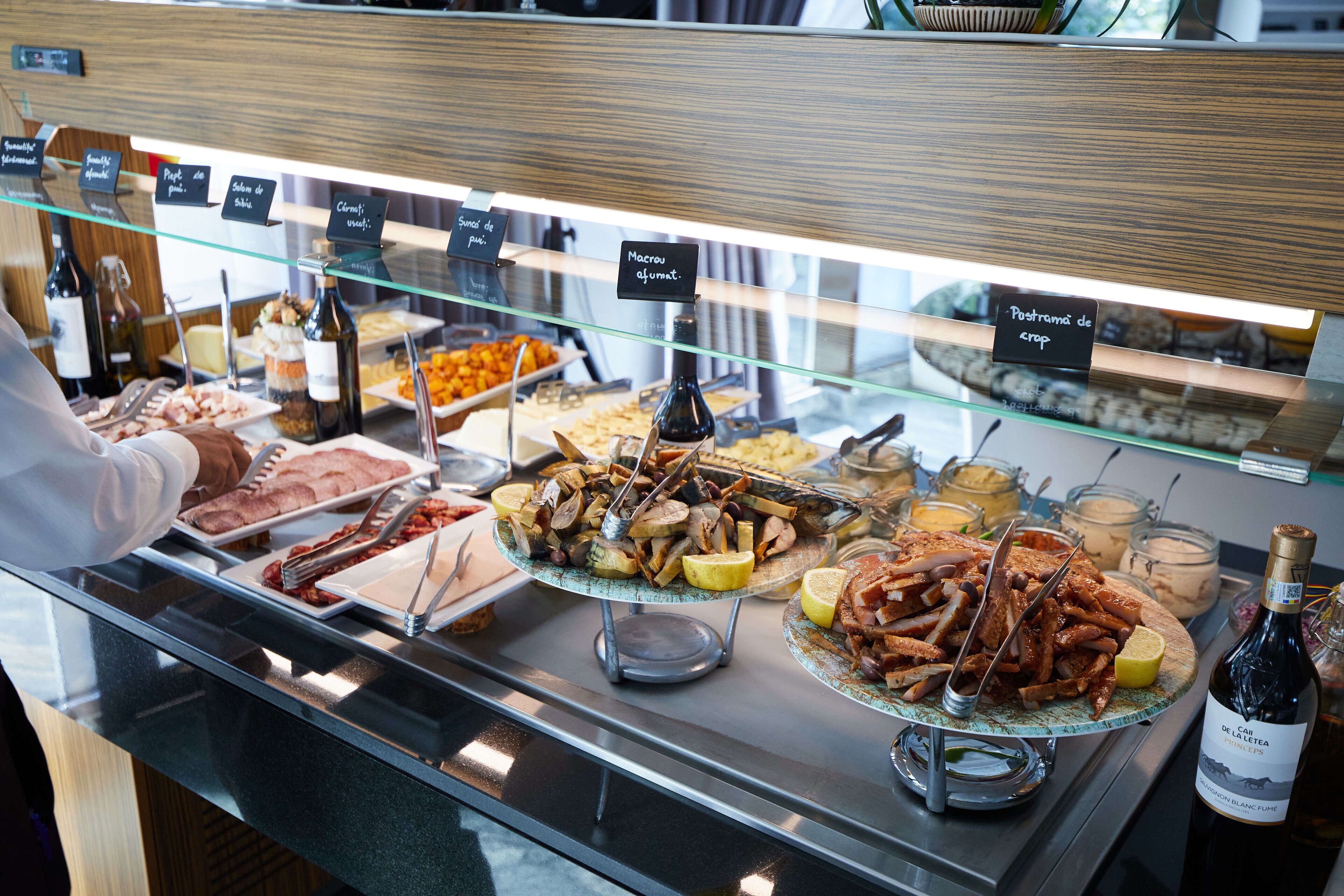 Monipuolinen buffet, jossa on tarjolla useita erilaisia ruokia, sekä pullo viiniä.