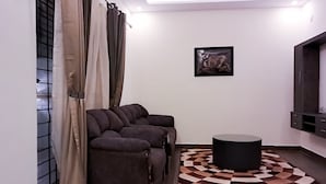 A modern living room with a sofa set, a round coffee table, and a patterned rug. - Roomshala 135 Paradise Villa Banglore (Devanahalli)