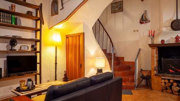 A cozy living room with a fireplace, a staircase, and a television. - Holiday Home 'Maison À Sigean' with Wi-Fi (Sigean)