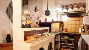 A kitchen with a stove, shelves, and various kitchen utensils. - Holiday Home 'Maison À Sigean' with Wi-Fi (Sigean)