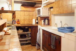 A kitchen with a microwave, sink, and various kitchen items.