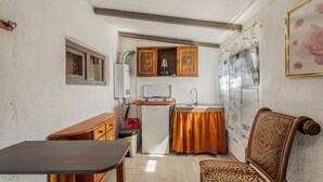 Una cocina compacta equipada con refrigerador, microondas y lavamanos pequeño.