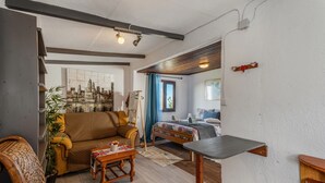 Una sala de estar con un sofá, una silla, una mesa y una cama.