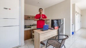 Uma cozinha moderna com um laptop Toshiba sobre a bancada, uma geladeira e uma placa indicando que é área exclusiva para funcionários.