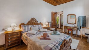 A bedroom with a wooden bed, a desk, a chair, a dresser, and a mirror. - Vacation Home 'Land Of Dreams' with Sea View, Shared Pool and Wi-Fi (Cruz de tea)