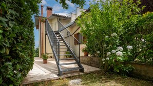 A staircase leading to a building with a tiled patio and potted plants.