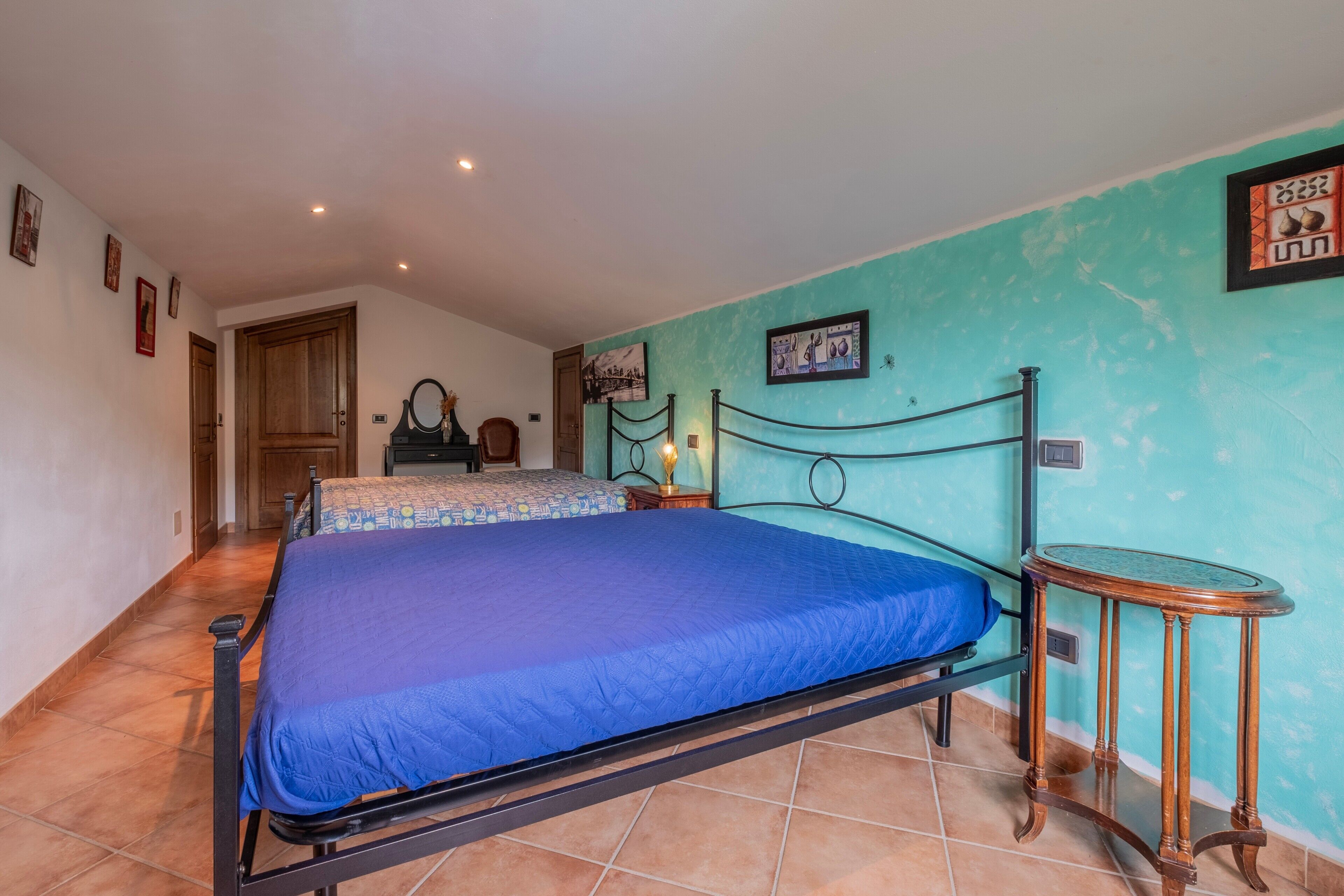 Une chambre à coucher comprenant un lit, une table de chevet, une chaise et une petite table.