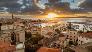 A coastal town with historic buildings, a marina, and a sunset over the water. - Holiday Home 'Villafranca' with Sea View, Wi-Fi and Air Conditioning (Alghero)