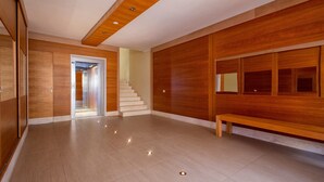 A spacious lobby with a wooden bench, a staircase, and a wooden wall panel. - Holiday Home 'Villafranca' with Sea View, Wi-Fi and Air Conditioning (Alghero)