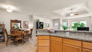 A spacious kitchen with wooden cabinets, a granite countertop, and a dining area with a wooden table and chairs. - A fresh new offering - Welcome to your Chico Getaway! (Chico)