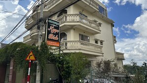 Un edificio de varios pisos con balcones y un cartel anunciando un negocio.