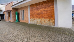 A building with a brick facade, a green vending machine, and a paved entrance area. - OYO Dupak Inn (Surabaya)