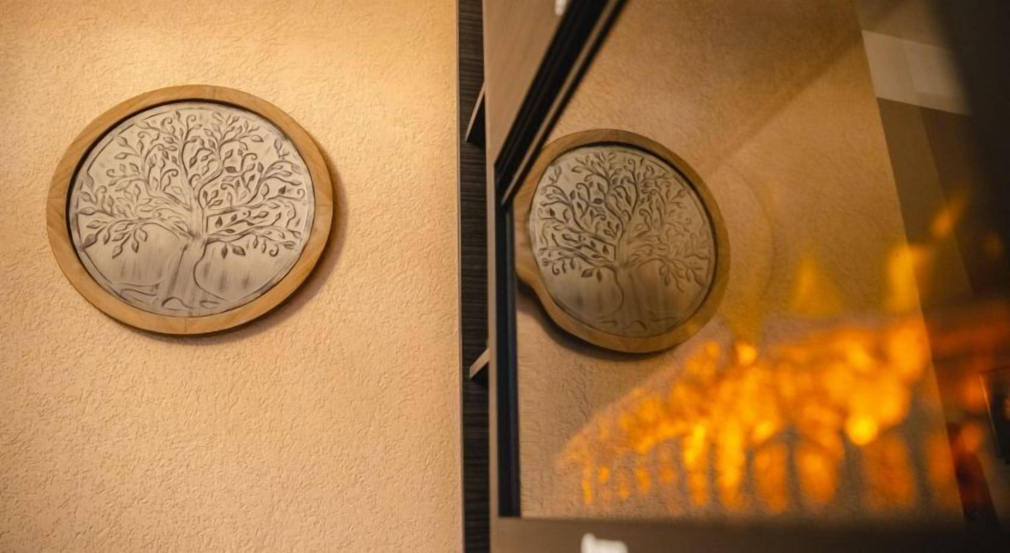 Dos paneles de madera fijados a la pared con elaborados diseños de árboles.