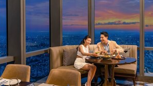 Ein Paar speist an einem Tisch mit Blick auf die Stadt.
