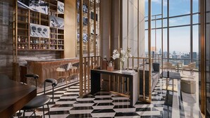 Ein modernes Interieur mit Bar, Sitzgelegenheiten und großen Fenstern mit Blick auf die Stadt.