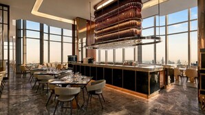 Ein moderner Essbereich mit Bar, großen Fenstern und Blick auf die Stadt.