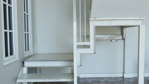 Una escalera conduce a una habitación con piso a cuadros y pared blanca.