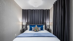 A hotel room with a large bed, two bedside tables, and a ceiling light. - 2BR The Cardinal C! Montrose, Downtown MedCenter ⭐️⭐️⭐️⭐️⭐️ (Houston)