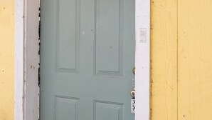 A door with a white frame and a light green door, marked with the letter 'C' on the wall. - 2BR The Cardinal C! Montrose, Downtown MedCenter ⭐️⭐️⭐️⭐️⭐️ (Houston)